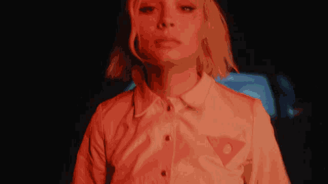 a woman in a white shirt with a red triangle on the pocket