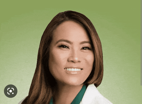 a woman in a white lab coat smiles with a green background behind her
