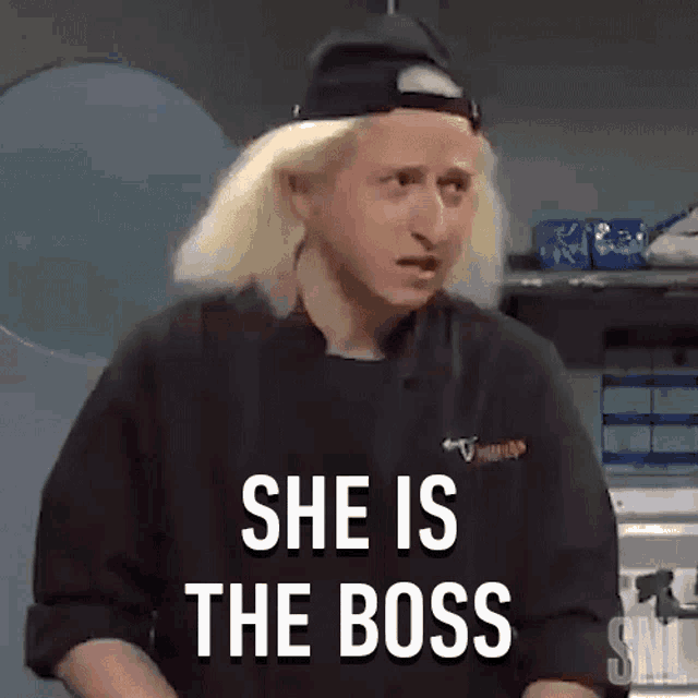 a woman with blonde hair is wearing a black hat and a chef 's jacket and says she is the boss .