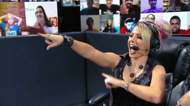 a woman wearing headphones and a microphone pointing at a screen that says fox