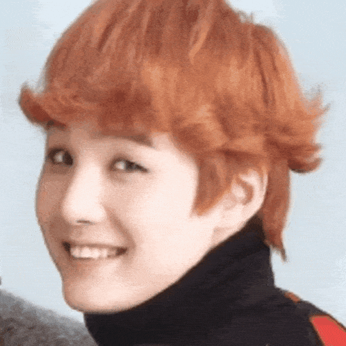 a close up of a woman 's face with red hair and a black turtleneck