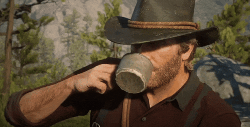 a man in a cowboy hat drinking from a cup