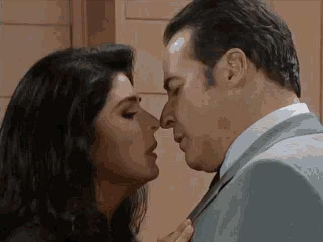 a man and a woman are touching noses and looking at each other