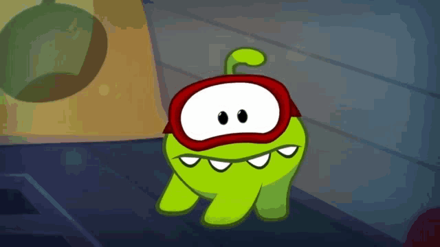 a green cartoon character wearing a red cape