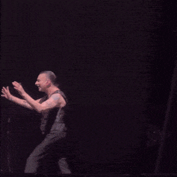 two men are dancing on a stage and one of them has the word aww written on his back
