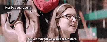 a girl wearing glasses is talking to another girl and says `` i never thought we would reach here . ''