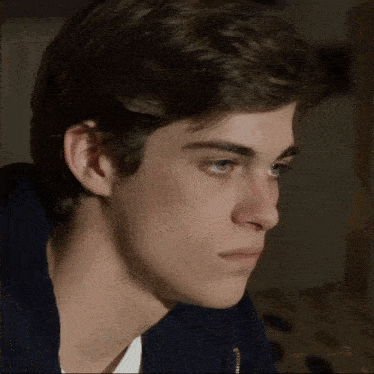 a close up of a young man 's face with a blue eye