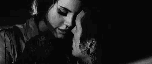 a black and white photo of a man and a woman kissing each other .