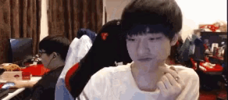 a young man is sitting in a chair in front of a computer monitor .