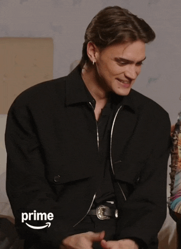 a man wearing a black jacket with the word prime on the bottom right