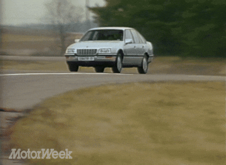 a silver sedan with a license plate that says senator cc is driving down a road