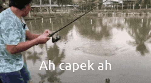 a man is fishing in a lake with ah capek ah written on the bottom of the image