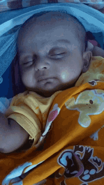 a baby is sleeping in a crib with a yellow blanket