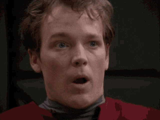 a close up of a man 's face with a surprised expression