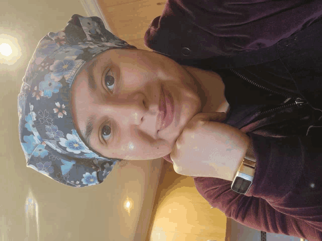 a woman wearing a floral scrub hat and a watch