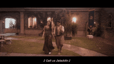 a man and a woman walking in front of a building with the words call us jaladdin