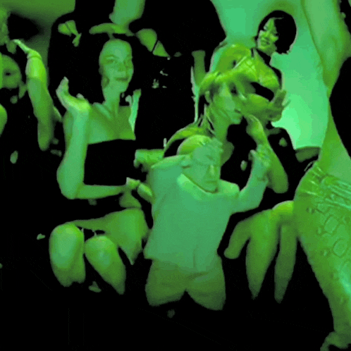 a group of people are posing for a picture in a green room