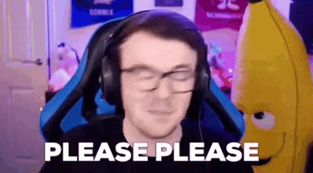a man wearing headphones and glasses is sitting in a chair with a stuffed banana .