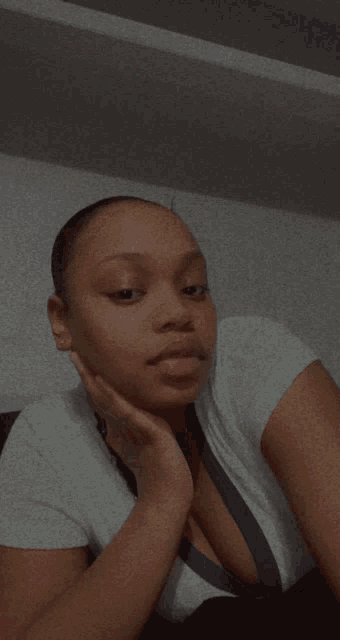 a woman with her eyes closed holds her hand to her face