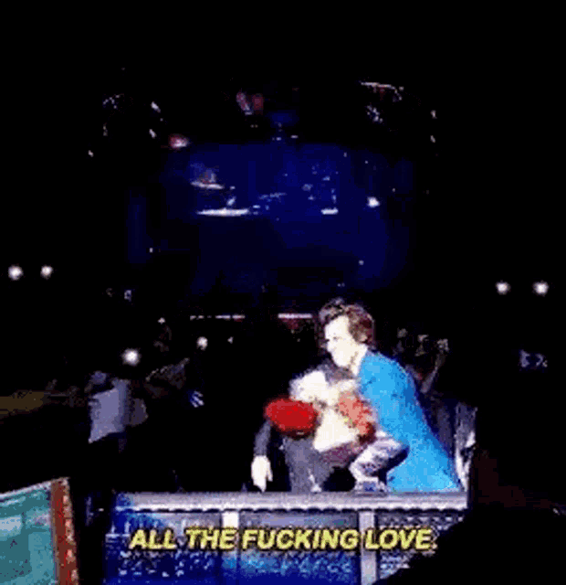a group of people are dancing on a stage and one of them is saying `` all the fucking love . ''