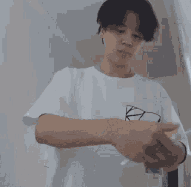 a man in a white shirt is standing in front of a door with korean writing on the wall