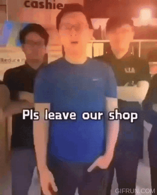 a man in a blue shirt says pls leave our shop in front of a group of men