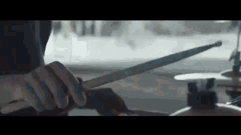 a person is holding a drum stick in their hand .