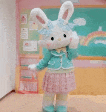 a stuffed bunny mascot is standing in front of a green board in a room .