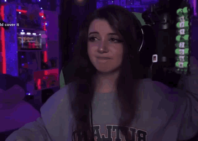 a woman wearing headphones is pointing at the camera with the words " id cover it " in the background