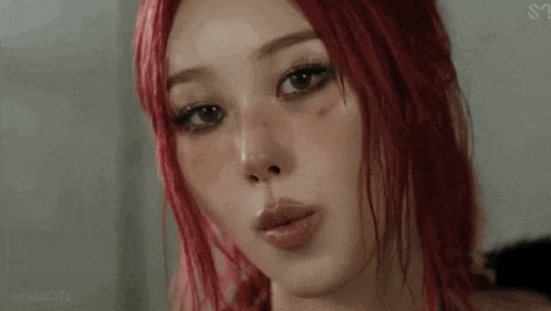 a woman with red hair is sticking her tongue out .
