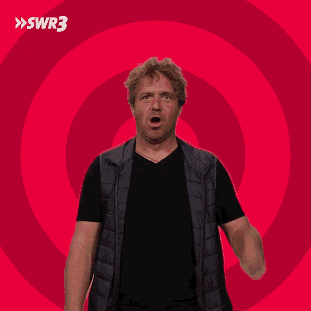 a man giving a thumbs up in front of a pink swirl with swr3 on it