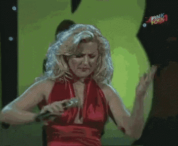 a blonde woman in a red dress is singing into a microphone with pink four written on the bottom