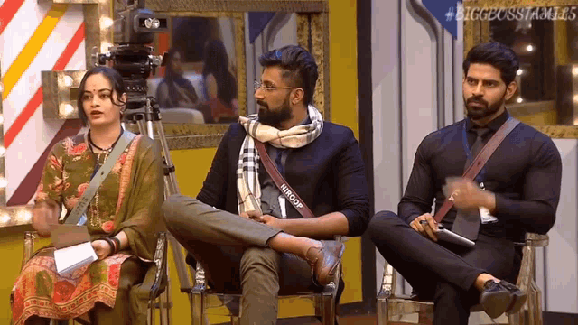 a group of people are sitting in front of a camera and a sign that says biggbossfamilies