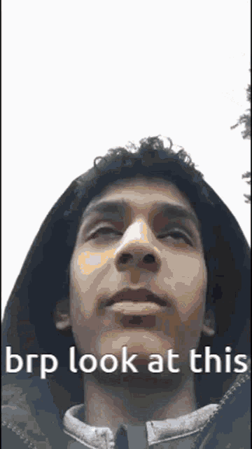 a young man wearing a hooded jacket is looking at the camera with the words brp look at this written on the bottom