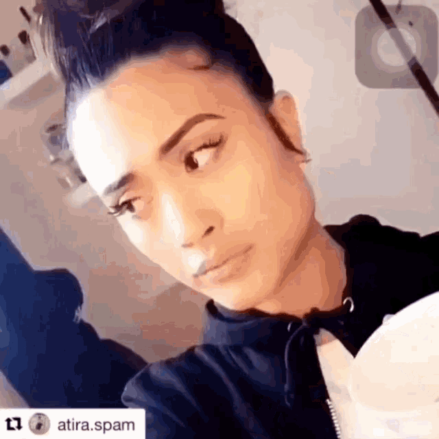 a close up of a woman 's face with the hashtag atira.spam below her