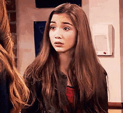 a young girl with long brown hair is standing next to another girl .