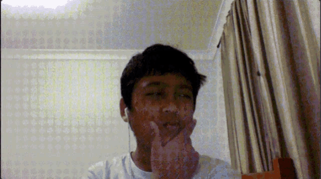 a young boy wearing earbuds looks at the camera