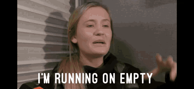 a woman says " i 'm running on empty " while standing in front of a window