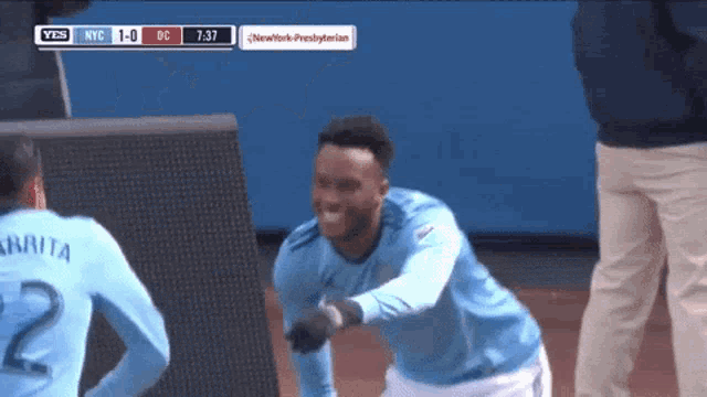 a soccer player wearing a number 2 jersey is celebrating a goal