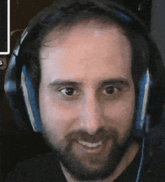 a man with a beard is wearing headphones and smiling at the camera