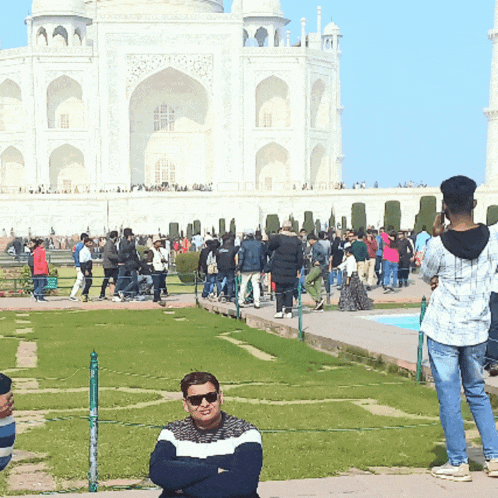 a man stands in front of a large white building