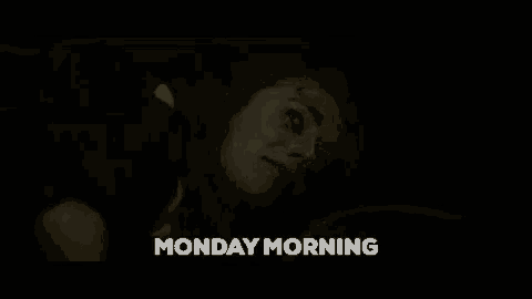 a woman is laying down in a dark room with the words monday morning written above her .