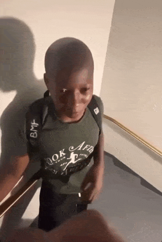 a boy wearing a green shirt that says " look aed "