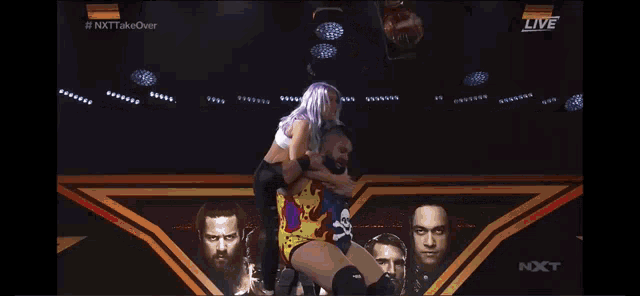 a woman with purple hair is laying on top of a man in a wrestling ring .
