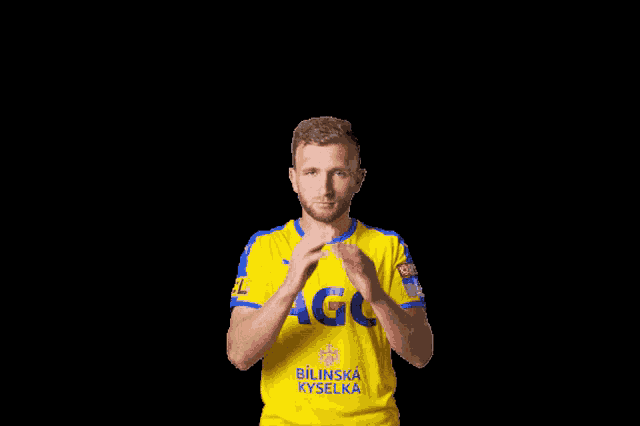 a man wearing a yellow shirt that says bilinska vyselka