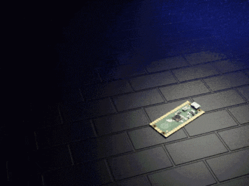 a small electronic device is laying on a black tiled floor