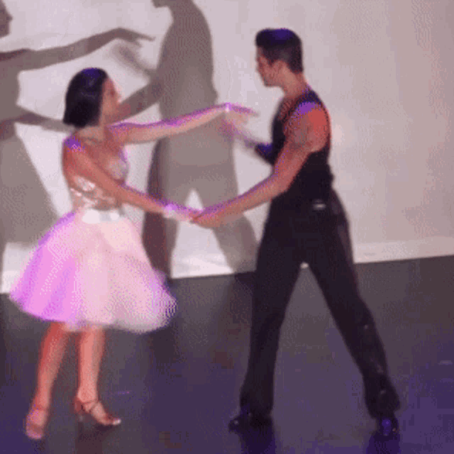 a man and a woman are dancing in front of a projection