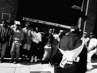 a group of men are standing in front of a brick building that says ' fame ' on it