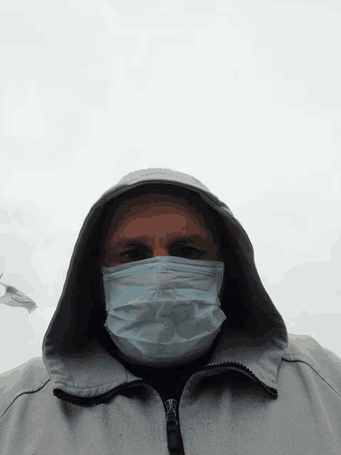 a man wearing a face mask and a hood