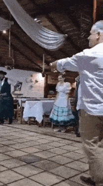 a man and a woman are dancing in a room while a man plays a guitar .